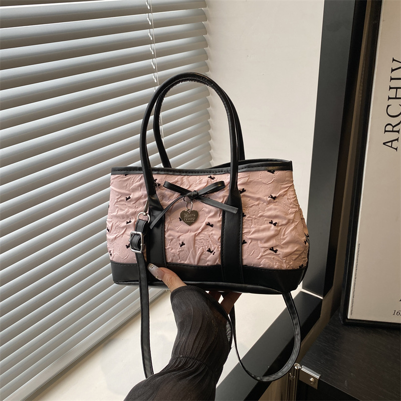 A new cross-border hand-held bucket bag for women in the summer of 2025, featuring a contrasting color combination and a simple texture. It is a single-shoulder crossbody bag full figure