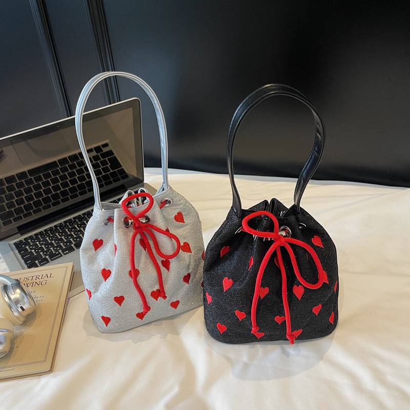 A niche and high-end embroidered heart-shaped hand-held canvas bag for Spring/Summer 2025, a mini bucket bag for single-shoulder crossbody Application Scenario