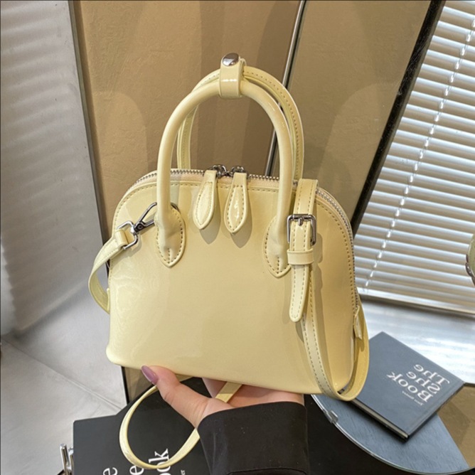 A new 2025 stylish, simple and versatile hand-held shell bag with a glossy finish and solid color for commuting. It's a casual single-shoulder crossbody bag full figure