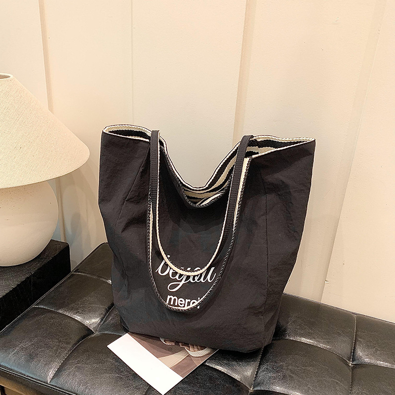 A casual and laid-back minimalist striped canvas bag for women, a new 2024 model with a niche design and large capacity single-shoulder tote bag details Picture