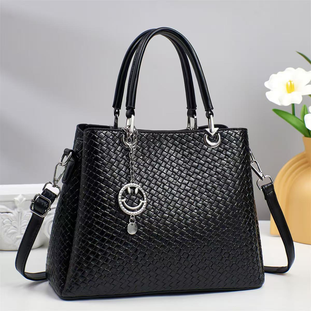 The 2025 new fashion woven fabric women's bag features exquisite hardware pendants, a stylish design and ingenious workmanship. It is a hand-held crossbody bag full figure