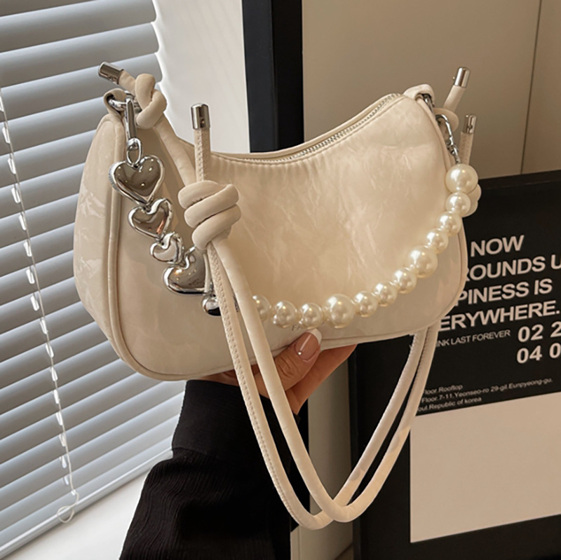 The new underarm bag for women in 2025 features a fashionable and niche design. This year, a solid-colored pearl versatile single-shoulder crossbody bag is in fashion full figure