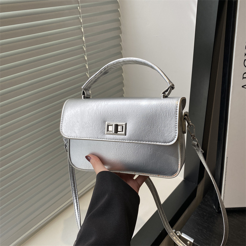 The 2025 new style women's bag is a fashionable Korean-style small square bag with a texture and lock buckle. It's a trendy small bag that can be carried by hand on one shoulder or under the armpits full figure
