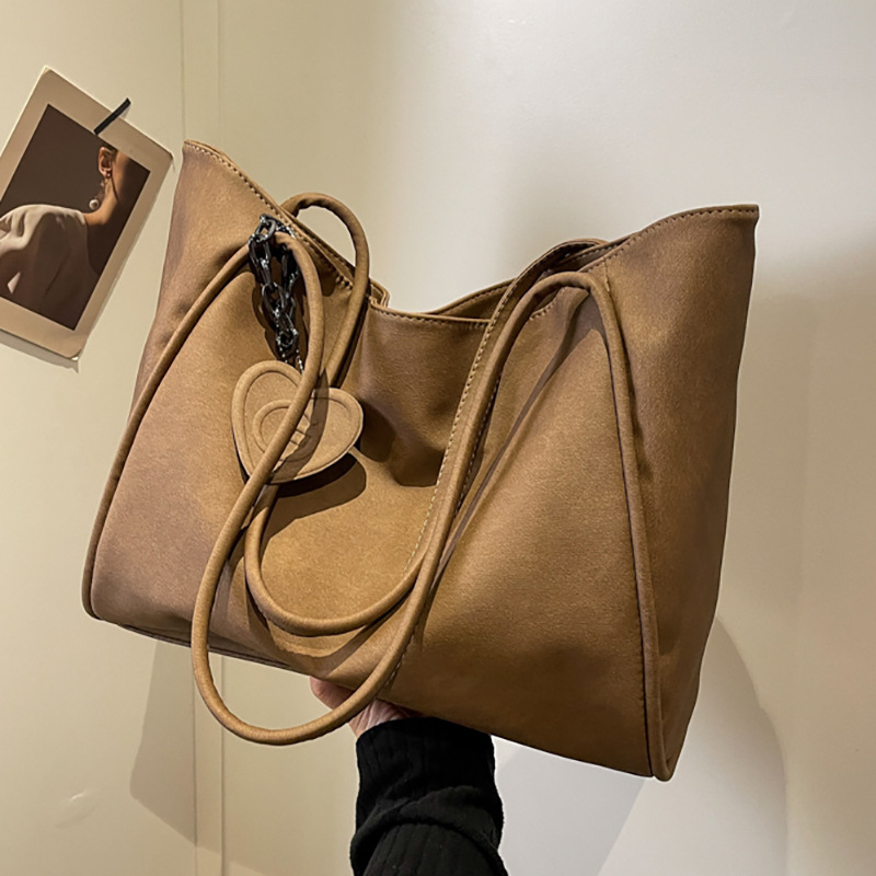 A new retro and simple single-shoulder bag with a large capacity for women in 2025, featuring a high-end texture. It is a tote bag for both class and casual commuting full figure