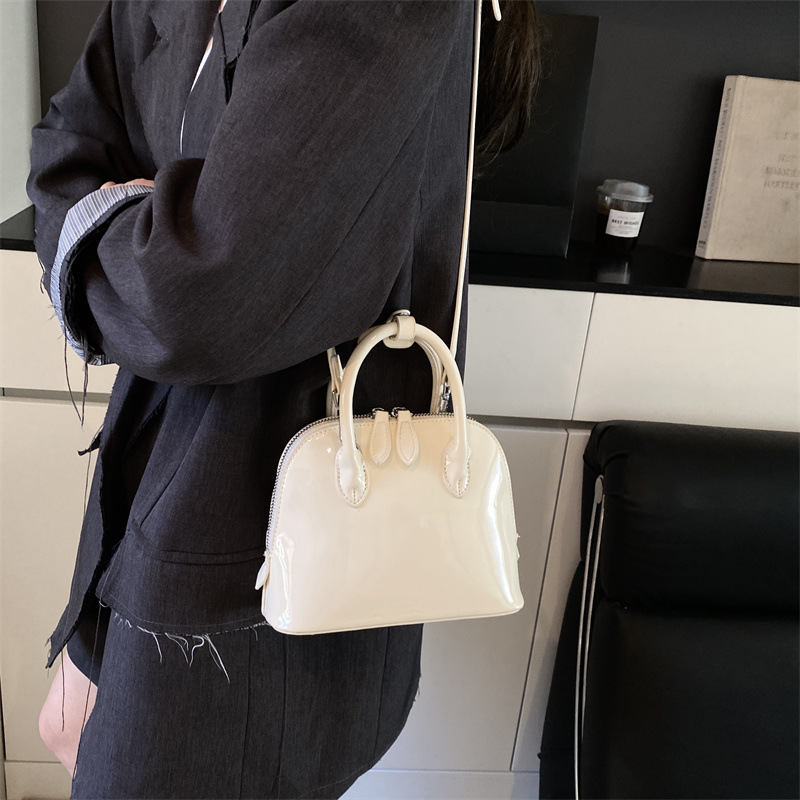 A new 2025 stylish, simple and versatile hand-held shell bag with a glossy finish and solid color for commuting. It's a casual single-shoulder crossbody bag details Picture
