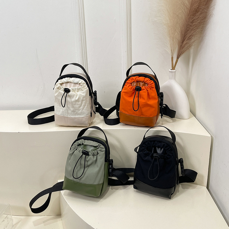 Color-blocking, lightweight, waterproof, spliced, casual and personalized small bag for Spring/Summer 2025, with a drawstring vertical crossbody phone bag Application Scenario