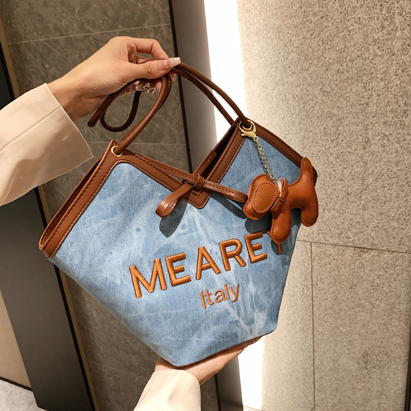 A niche design denim blue tote bag for casual commuting in 2025, a trendy and versatile single-shoulder bag full figure