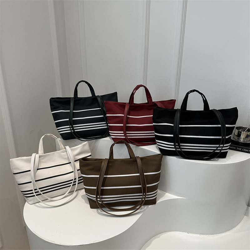 A new Korean canvas bag, striped hand-held shoulder tote bag, large-capacity women's bag, versatile commuting crossbody bag Application Scenario
