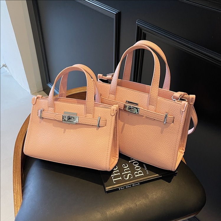 This is a trendy and stylish hand-held Kelly bag with a lychee pattern for women's summer 2025. It's a chic single-shoulder crossbody bag full figure