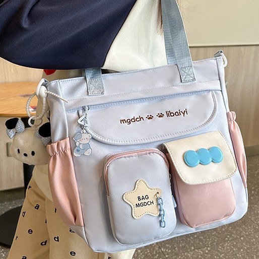 The new schoolbag for women is a large-capacity crossbody bag with a contrasting color for students. It is versatile, reduces the burden, and is fashionable and trendy with a cartoon single-shoulder design full figure