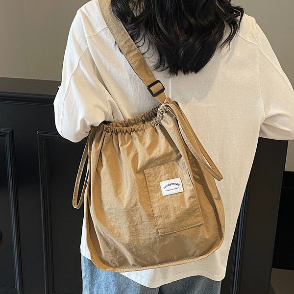 The 2025 new lightweight handbag is a small and exquisite cloth bag with a solid color and simple drawstring. It is a student portable single-shoulder bag full figure
