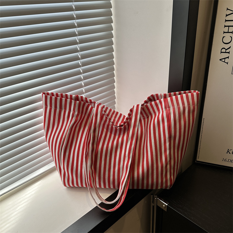 A niche design sense commuter striped canvas tote bag for women, a new 2024 large-capacity casual hand-held shoulder bag full figure