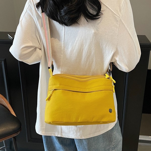 The 2025 new women's crossbody bag is a lightweight fabric small bag with a light and casual single-shoulder design. It is simple and versatile on one shoulder full figure