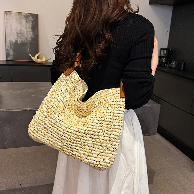 This is a versatile, simple, woven and hollowed-out women's 2025 spring new hand-held bucket bag and casual shoulder bag full figure