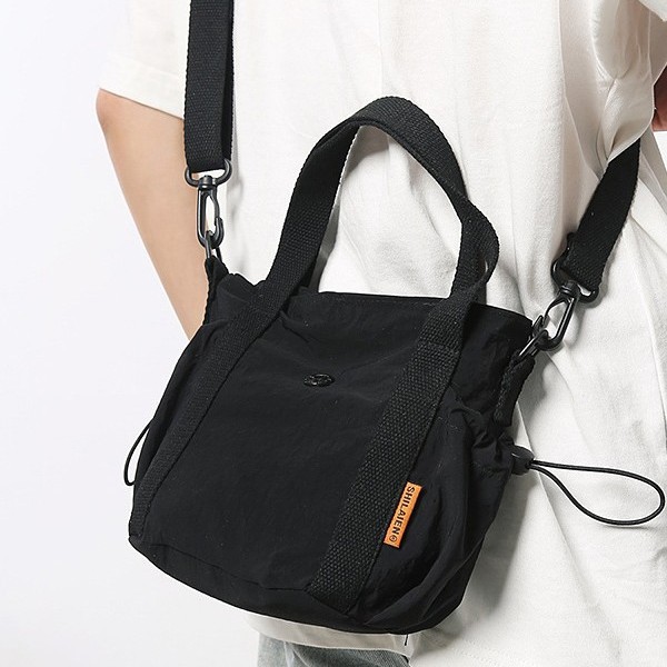 A new casual and fashionable Korean-style hand-held nylon bucket bag for men and women, a light, simple and versatile crossbody bag details Picture