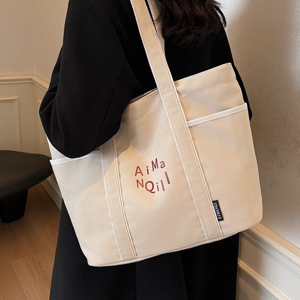 The casual canvas tote bag is a versatile women's bag for autumn and winter 2024. It is a simple, large-capacity, lightweight single-shoulder bag for going out details Picture