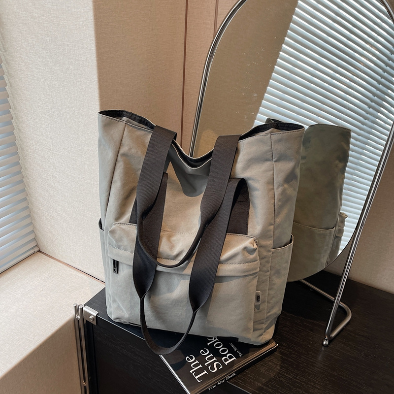 Large-capacity casual and simple single-shoulder bag, a hand-held cloth bag for college students to attend classes, a commuting bag for work, and a storage bag for tablet computers full figure