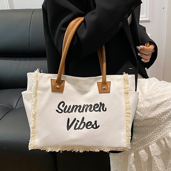 The 2025 new Korean-style letter-fringed canvas bag for women, a large-capacity, simple commuting student single-shoulder tote bag Application Scenario