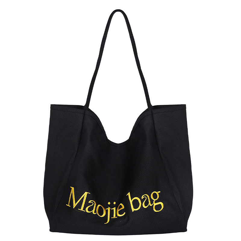 The 2025 summer new letter niche design Korean-style canvas bag is a large-capacity commuting casual hand-held cloth bag for women Item Picture