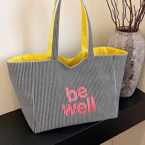 A new large-capacity tote double-sided striped casual single-shoulder textured lettered canvas bag for student commuting from South Korea Application Scenario