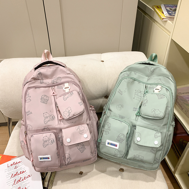 The new style of schoolbag for girls is cute and has a large capacity. It features a cartoon print backpack with multiple pockets, a coin purse and a practical backpack details Picture