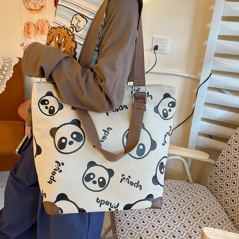 A niche new 2025 Panda hand-held canvas bag for girls to attend classes, a crossbody bag for college students, and a single-shoulder bag for commuting and going out full figure