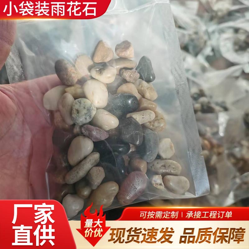 Small bags of rain flower stones, colored pebbles for paving the ground and roads, courtyard and garden landscaping. The rain flower stones are white and the original stones are black full figure