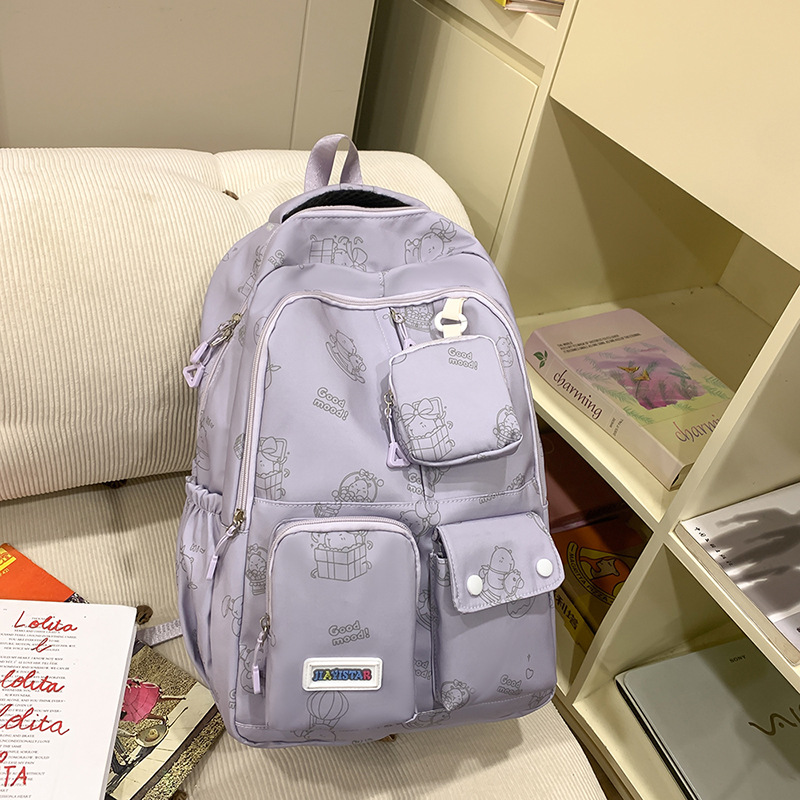 The new style of schoolbag for girls is cute and has a large capacity. It features a cartoon print backpack with multiple pockets, a coin purse and a practical backpack full figure
