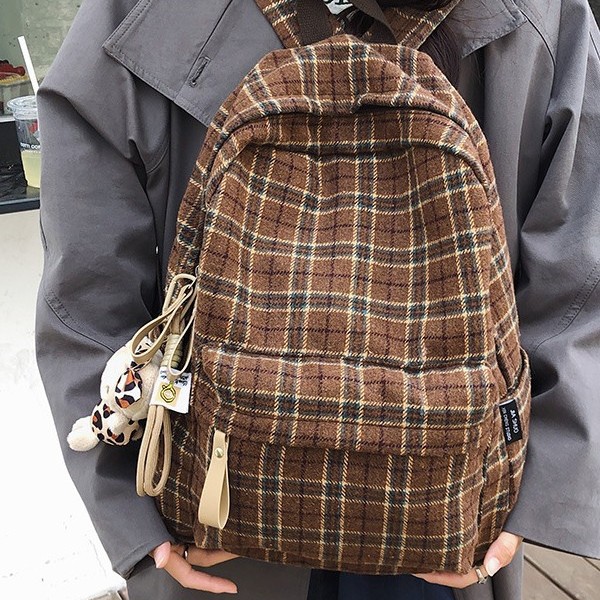 The new autumn and winter backpack is cute. It's a large-capacity backpack with a woolen checkered pattern design Specification drawing