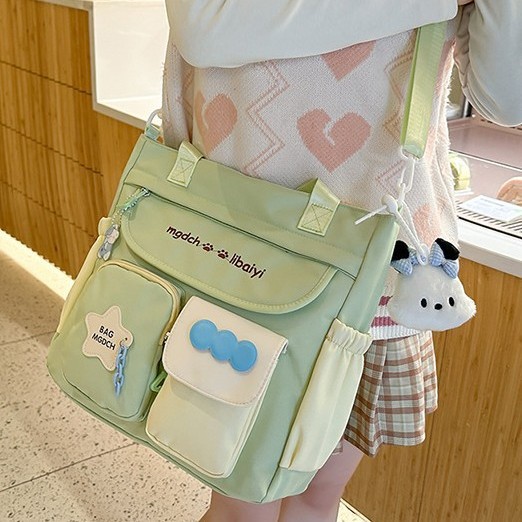 The new schoolbag for women is a large-capacity crossbody bag with a contrasting color for students. It is versatile, reduces the burden, and is fashionable and trendy with a cartoon single-shoulder design details Picture