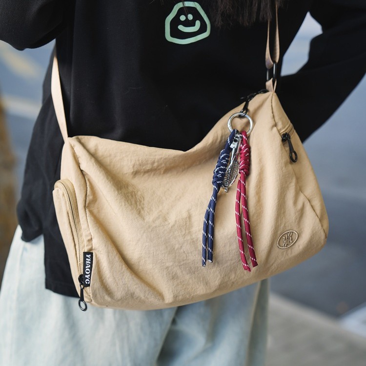 A trendy new lightweight single-shoulder crossbody bag for both men and women, a Japanese-style commuter casual couple bag, and a sports student bag full figure