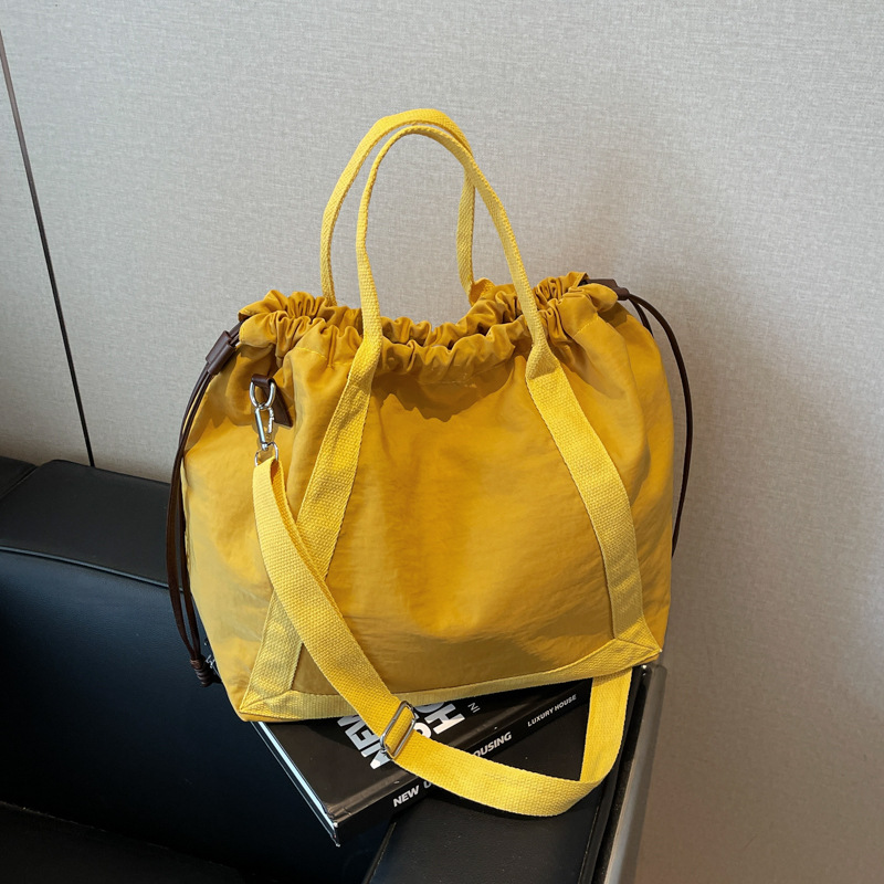 Large-capacity student commuting crossbody bag, simple and versatile female dopamine tote bag, drawstring design crossbody bag full figure