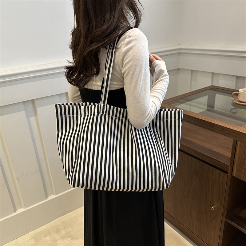 A niche design sense commuter striped canvas tote bag for women, a new 2024 large-capacity casual hand-held shoulder bag details Picture