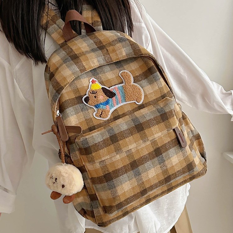 This is a new large-capacity backpack with a checkered pattern for autumn and winter. It features a cute puppy and a versatile student bag details Picture