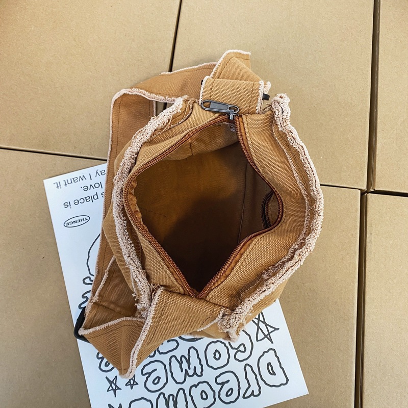 Japanese-style washed canvas bag for women, solid color, casual and niche single-shoulder crossbody bag, with unique fringed stitching and artistic mobile phone bag Application Scenario