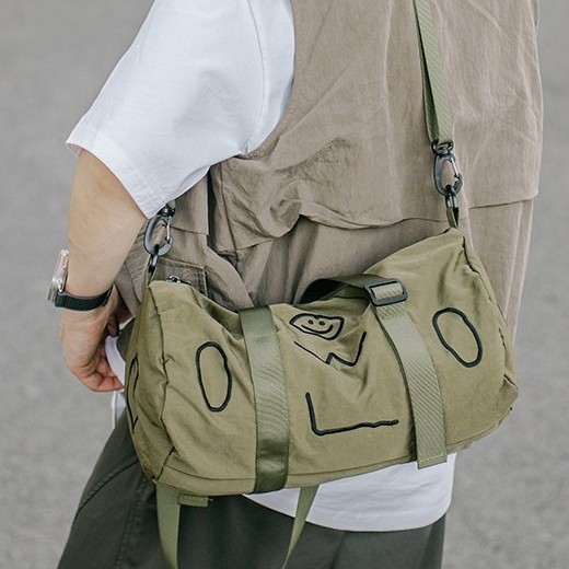A new 2025 fashionable single-shoulder bag with a smiling face pattern for both men and women, a hand-held crossbody bag with a letter zipper and a casual cylindrical bag details Picture