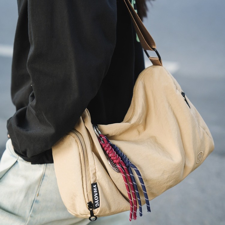 A trendy new lightweight single-shoulder crossbody bag for both men and women, a Japanese-style commuter casual couple bag, and a sports student bag Application Scenario