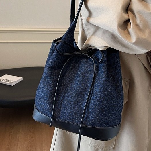 The new autumn and winter design style denim bucket bag, high-end and laid-back with a bow seal, single-shoulder bag, fashionable and large-capacity bag full figure