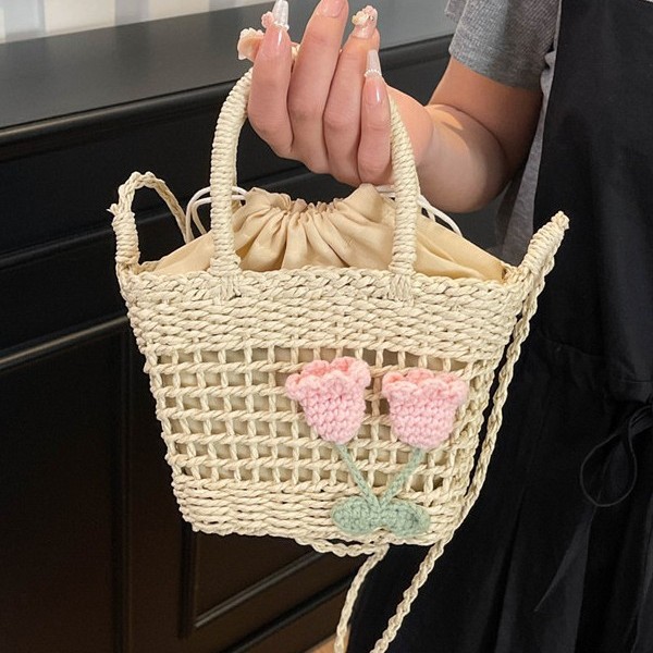 A new fashion single-shoulder crossbody bag for women in 2025, featuring straw and flower weaving. It is a French high-end hand-held bucket bag full figure