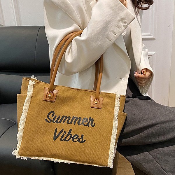 The 2025 new Korean-style letter-fringed canvas bag for women, a large-capacity, simple commuting student single-shoulder tote bag details Picture