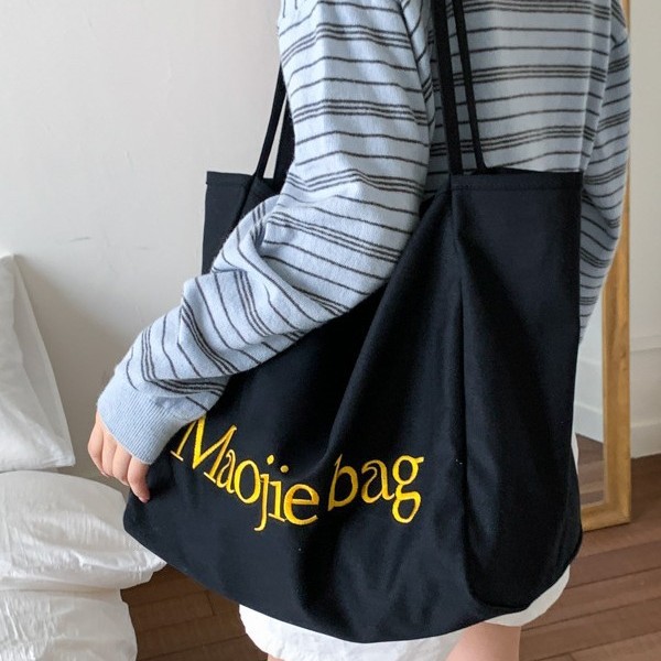 The 2025 summer new letter niche design Korean-style canvas bag is a large-capacity commuting casual hand-held cloth bag for women details Picture
