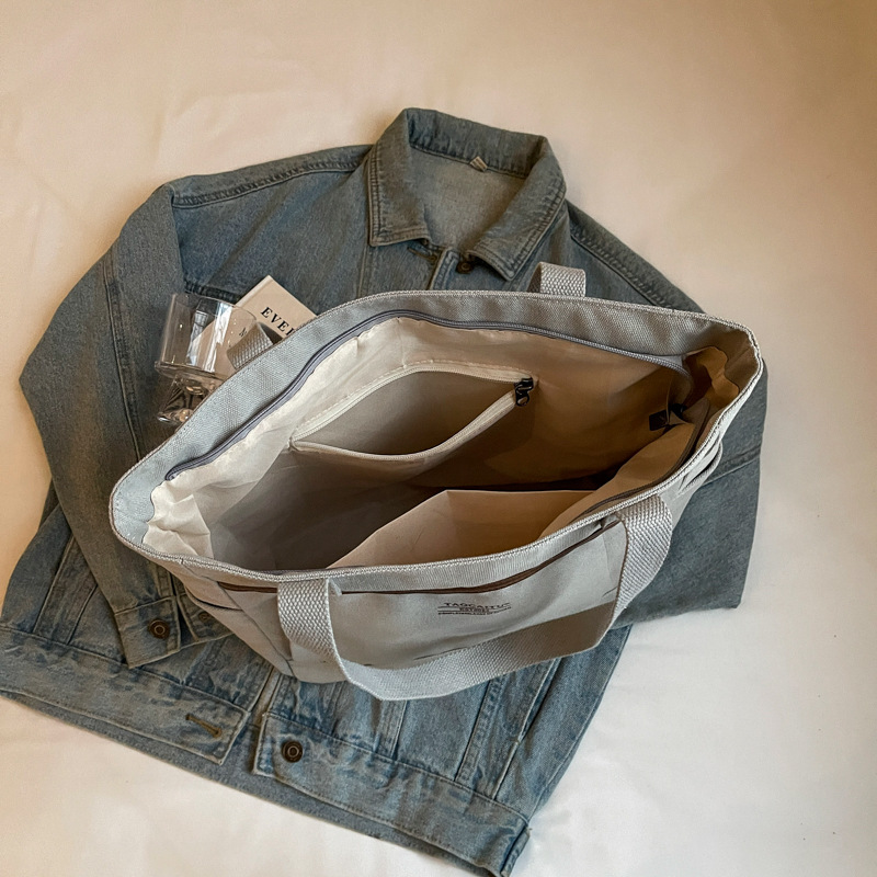 A new Korean-style canvas large bag for women, simple and casual hand-held shoulder bag, versatile texture, student tote bag for class Application Scenario