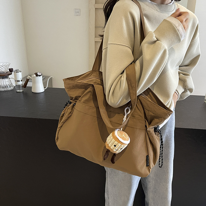A minimalist tote bag from a trendy women's brand, with a niche design and a Harajuku style, a high-quality commuter single-shoulder bag, and a Maillard color handbag full figure