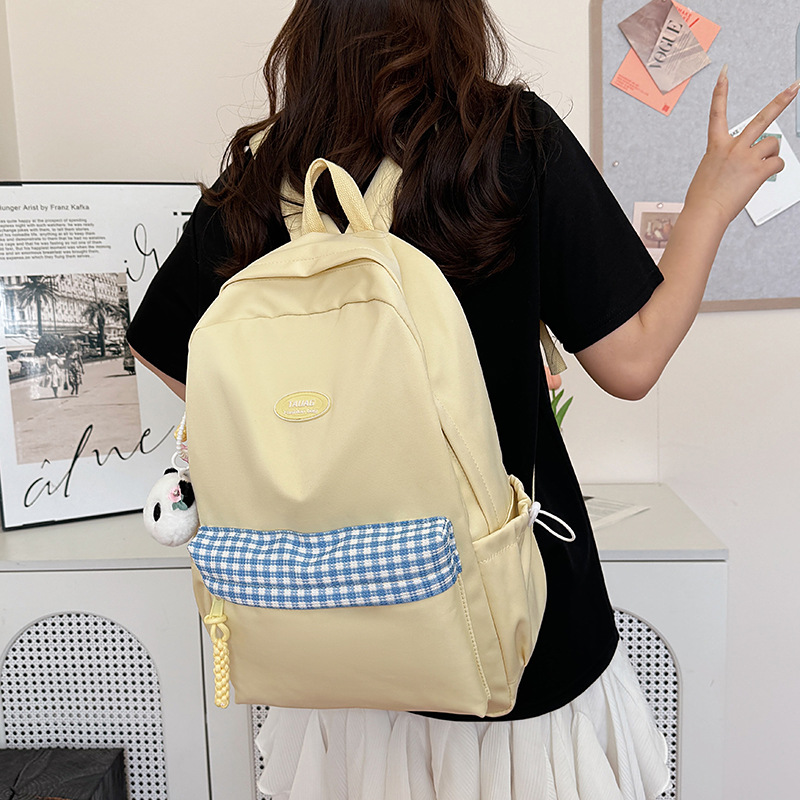 The new fresh and sweet checkered backpack is a casual, simple, lightweight and versatile large-capacity backpack for high school and junior high school students full figure