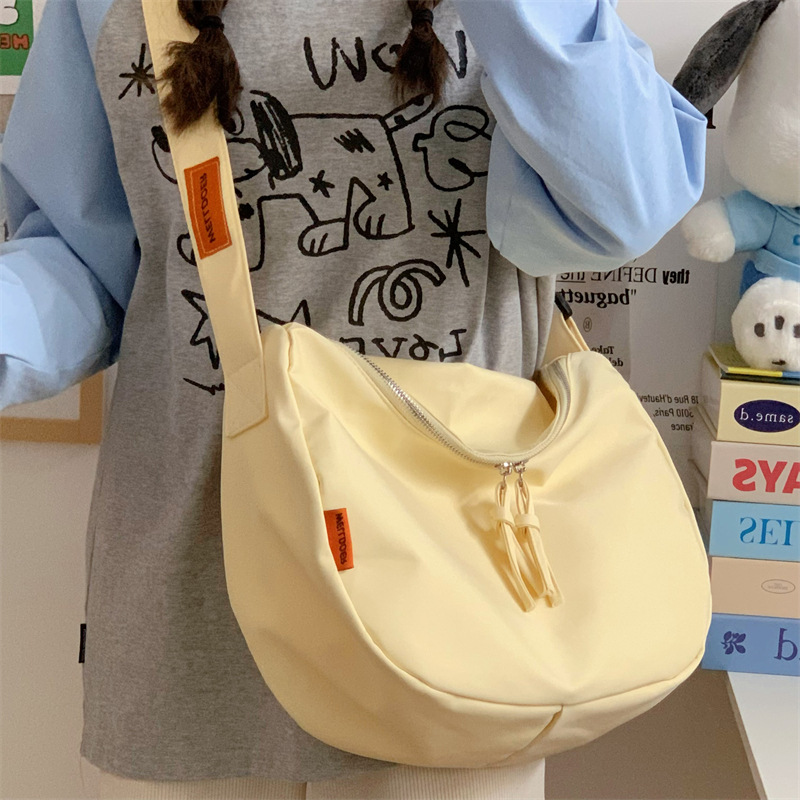 A Japanese InS-style casual and versatile crossbody bag for female college students commuting to class in a simple and artistic solid color tote bag full figure