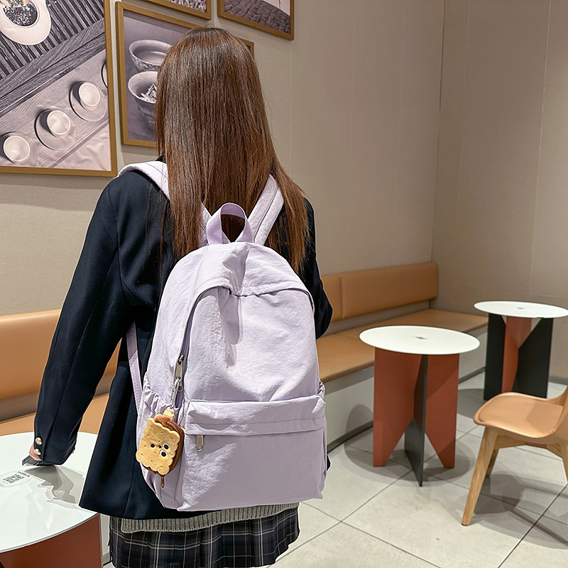 A new minimalist Japanese-style ins solid color backpack for college students, a casual campus schoolbag, and a versatile lightweight backpack for travel full figure