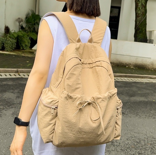 A new minimalist backpack with a Korean niche design, versatile travel backpack, lightweight solid color and large capacity student schoolbag full figure