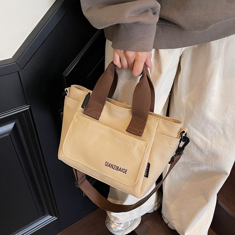 The 2025 new style of fashionable and casual canvas bag is versatile and has a large capacity. It is a niche handbag and a simple Korean-style commuter tote bag details Picture