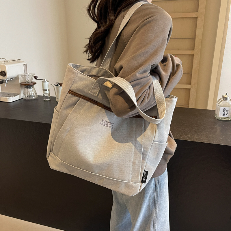 A new Korean-style canvas large bag for women, simple and casual hand-held shoulder bag, versatile texture, student tote bag for class full figure