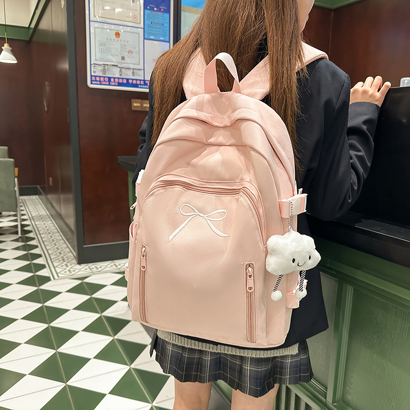 A new solid-color cute bow backpack with a high aesthetic level. It is a versatile backpack for junior and senior high school students, suitable for commuting and travel details Picture